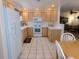 Bright kitchen with white appliances, light wood cabinets, and white tile flooring at 15225 N 100Th St # 1220, Scottsdale, AZ 85260