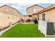 Well-maintained backyard with artificial turf, a patio seating area, and privacy fencing at 1557 S Halsted Dr, Chandler, AZ 85286