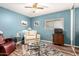 Cozy bedroom with blue walls, a ceiling fan, and a glass coffee table on a patterned rug at 1557 S Halsted Dr, Chandler, AZ 85286