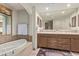 Luxurious bathroom with a soaking tub, double vanities, and a large mirror at 15802 N 71St St # 311, Scottsdale, AZ 85254