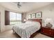 Comfortable bedroom featuring a ceiling fan, a large window with wooden shutters, and bedside tables at 15802 N 71St St # 311, Scottsdale, AZ 85254