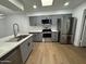 Modern kitchen with stainless steel appliances, gray cabinets, quartz countertops, and wood flooring at 1620 E Jacinto Ave, Mesa, AZ 85204