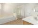 Bright bathroom with soaking tub, glass enclosed shower, double sinks, and modern fixtures at 16238 N 22Nd Ln, Phoenix, AZ 85023