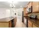 View of the kitchen and dining area featuring wood cabinets, kitchen island, and stainless steel appliances at 16238 N 22Nd Ln, Phoenix, AZ 85023