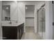 Bright bathroom featuring a double vanity with quartz countertops and a glass-enclosed shower at 17567 W Adams St, Goodyear, AZ 85338