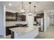 Modern kitchen with dark cabinets, stainless steel appliances, and a spacious island with granite countertops at 17567 W Adams St, Goodyear, AZ 85338
