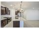 Modern kitchen featuring an island with quartz countertops, stainless appliances, and dark cabinets at 17567 W Adams St, Goodyear, AZ 85338