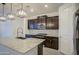 Modern kitchen with dark cabinets, granite countertops, stainless appliances, and a large kitchen island at 17567 W Adams St, Goodyear, AZ 85338