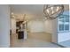 Open-concept living area with a view of the kitchen with an island and dark cabinets, and modern lighting fixtures at 17567 W Adams St, Goodyear, AZ 85338