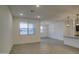 Open-concept living room with tile flooring, large windows, and modern light fixtures at 17567 W Adams St, Goodyear, AZ 85338