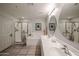 Bathroom featuring walk-in shower, soaking tub, double sinks, and neutral tiling at 19700 N 76Th St # 1124, Scottsdale, AZ 85255