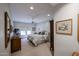 Bright primary bedroom with plush carpet, decorative armoire, and stylish bedroom furniture at 19700 N 76Th St # 1124, Scottsdale, AZ 85255