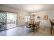 Dining area with sliding glass door leading to patio, chandelier, flowers, and stylish table setting at 19700 N 76Th St # 1124, Scottsdale, AZ 85255