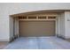 Attached single-car garage with tan door and concrete driveway at 19700 N 76Th St # 1124, Scottsdale, AZ 85255