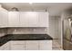 Updated kitchen with white cabinets, black granite counters, and stainless steel refrigerator at 19700 N 76Th St # 1124, Scottsdale, AZ 85255