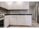 This kitchen features white cabinetry, a gray backsplash, and a dark countertop at 19700 N 76Th St # 1124, Scottsdale, AZ 85255