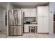 A stainless steel refrigerator complements the kitchen's white cabinetry and desk space at 19700 N 76Th St # 1124, Scottsdale, AZ 85255