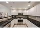 Well-lit kitchen boasts white cabinetry, black granite countertops, and stainless steel appliances at 19700 N 76Th St # 1124, Scottsdale, AZ 85255