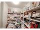 Organized walk-in pantry with shelving storing kitchenware and linens for convenient storage at 19700 N 76Th St # 1124, Scottsdale, AZ 85255