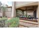 A covered patio featuring a ceiling fan, stone accents, outdoor furniture, and desert landscaping at 19700 N 76Th St # 1124, Scottsdale, AZ 85255