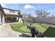 Lush backyard featuring artificial turf, a putting green, an outdoor kitchen, and a covered patio at 20897 W Edith Way, Buckeye, AZ 85396