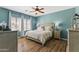 Bright bedroom features an elegant bed frame, wood floors, and modern ceiling fan at 20897 W Edith Way, Buckeye, AZ 85396