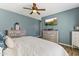 Comfortable bedroom with wood floors, blue walls, and a large TV at 20897 W Edith Way, Buckeye, AZ 85396