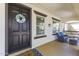 Inviting front porch featuring a dark entry door, comfortable seating, and stylish decor at 20897 W Edith Way, Buckeye, AZ 85396