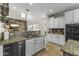 A modern kitchen featuring granite countertops, stainless steel appliances and a breakfast bar looking into the living room at 20897 W Edith Way, Buckeye, AZ 85396