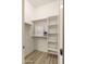 Walk-in closet with white shelving and wood-look flooring at 22318 S 226Th Pl, Queen Creek, AZ 85142