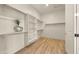 Walk-in closet featuring built-in shelving and wood-look floors at 22318 S 226Th Pl, Queen Creek, AZ 85142