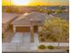 Aerial view of a charming home with a three-car garage, xeriscaped yard, and mature tree at 22318 S 226Th Pl, Queen Creek, AZ 85142