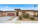 Charming front exterior with a two-car garage and professionally landscaped, low-maintenance yard at 22318 S 226Th Pl, Queen Creek, AZ 85142
