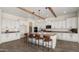 Bright kitchen features white cabinets, wood beams, stainless steel appliances, and a large center island with bar seating at 22318 S 226Th Pl, Queen Creek, AZ 85142
