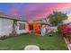 Well-maintained backyard with artificial grass, covered patio, and vibrant bougainvillea for added privacy at 2321 N Glenview --, Mesa, AZ 85213