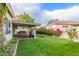 Relaxing backyard with artificial grass, covered patio, and lush landscaping for ultimate privacy at 2321 N Glenview --, Mesa, AZ 85213