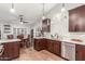 Kitchen featuring dark wood cabinetry, tile backsplash, stainless steel dishwasher, and light-colored counters at 2321 N Glenview --, Mesa, AZ 85213