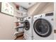 Bright laundry room featuring a front load washer and dryer with storage shelves at 2321 N Glenview --, Mesa, AZ 85213