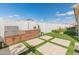 Outdoor kitchen with built-in grill and wooden cabinets surrounded by artificial grass at 24626 N 143Rd Dr, Surprise, AZ 85387