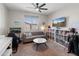 Playful bedroom with a gray sofa, display shelves with a TV, and an adjacent gaming chair at 24626 N 143Rd Dr, Surprise, AZ 85387