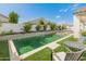 Backyard pool with outdoor seating, artificial grass and a water feature surrounded by flowers at 24626 N 143Rd Dr, Surprise, AZ 85387