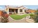 Well-maintained backyard with artificial turf, a covered patio, hot tub, and desert landscaping for low-maintenance living at 27467 W Osprey Dr, Buckeye, AZ 85396
