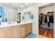 Modern bathroom featuring a double vanity, ample lighting, and walk-in closet access at 27467 W Osprey Dr, Buckeye, AZ 85396