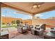 Inviting covered patio with comfortable seating, stylish decor, and a ceiling fan overlooking a well-manicured backyard at 27467 W Osprey Dr, Buckeye, AZ 85396
