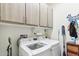 Well-equipped laundry room with LG washer and dryer, overhead cabinets, and organized storage at 27467 W Osprey Dr, Buckeye, AZ 85396