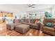 Open-concept living room and kitchen with hardwood floors, a comfortable sofa, and plenty of natural light at 27467 W Osprey Dr, Buckeye, AZ 85396
