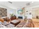 Cozy living room with a modern fireplace, sleek fan, wood floors, and comfortable leather furnishings at 27467 W Osprey Dr, Buckeye, AZ 85396