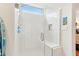 Modern tiled shower with a glass enclosure, bench seating, window, and niche for toiletries creates a spa-like experience at 27467 W Osprey Dr, Buckeye, AZ 85396