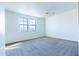 Sunlit bedroom features neutral carpet, two windows, and a ceiling fan at 29120 N 22Nd Ave # 205, Phoenix, AZ 85085