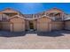 View of multi-unit townhome showcasing well-maintained exteriors, garages, and paver driveway at 29120 N 22Nd Ave # 205, Phoenix, AZ 85085